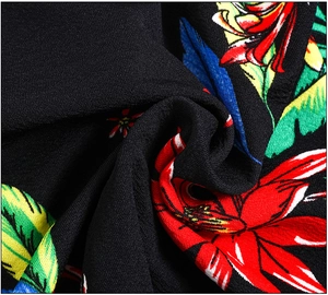 Détail macro de tissu à imprimé floral tropical sur fond noir à texture fine