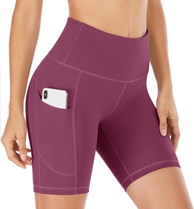 Detail of high waisted burgundy biker shorts featuring a functional side phone pocket
