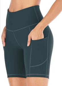 Detail of high-waist teal yoga shorts featuring side pockets and reinforced seams