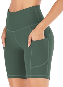 Detail of high-waist dark green yoga shorts with side pocket and flatlock stitching