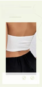 Dettaglio del top bianco con schiena scoperta e trama in rilievo abbinato a pantaloni neri