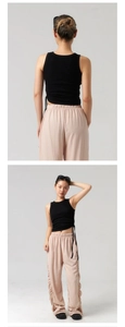 Dettaglio di top corto nero con coulisse e pantaloni rosa a gamba larga plissettati