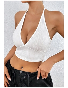 Dettaglio del crop top bianco con scollo a V, tessuto testurizzato e schiena scoperta