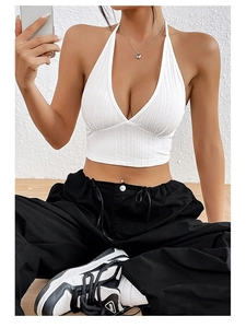 Dettaglio del crop top bianco con scollo a V e allacciatura al collo in tessuto a coste