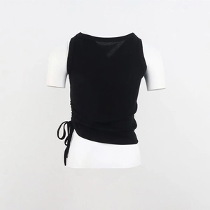 Dettaglio di un top nero in maglia con coulisse laterale arricciata e orlo asimmetrico