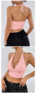 Dettaglio del crop top rosa con scollo all'americana, tessuto a rilievo e lacci