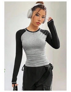 Detail view of women's raglan sleeve top with grey body, black sleeves and side ruching