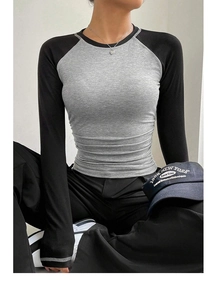 Close-up of slim-fit colorblock top with gray body, black sleeves and heart necklace
