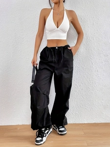 Top bianco a scollo a V con lacci sulla schiena e pantaloni neri a gamba larga