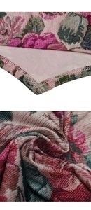 Dettaglio del tessuto a fiori rosa con cuciture overlock e trama a costine morbide