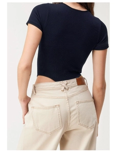 Detail of navy blue ribbed bodysuit fabric and slim fit design on a model