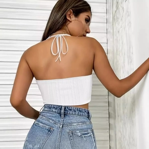 Dettaglio del design intrecciato sul retro di un top bianco a lupetto con jeans
