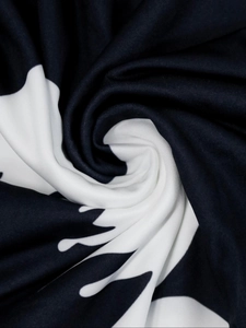 Close-up of butterfly print fabric with abstract black and white spiral knit textures