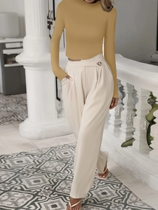 Damesensemble met gemberkleurige coltrui met lange mouwen en crèmekleurige broek met hoge taille