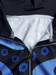 Gros plan d'une fermeture éclair et motif circulaire abstrait sur veste bleue et noire