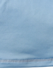 Gros plan sur un haut en tricot bleu clair montrant les coutures et la texture du tissu
