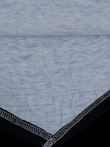 Gros plan détaillé du tissu gris et noir avec coutures blanches d'un t-shirt floral 3D