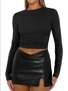 Women's black long sleeve crop top paired with a high-waisted faux leather mini skirt