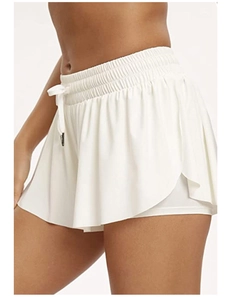 Detail of white high-waisted sports skort with adjustable drawstring and layered design