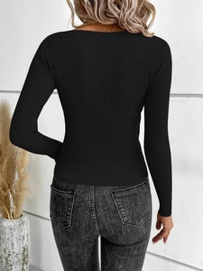Close-up of the black ribbed knit fabric and slim-fit texture on the long sleeve top