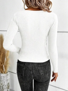Close-up of white ribbed knit fabric texture and irregular cross design on long sleeve top