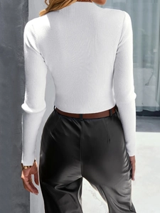 Back view of woman in white ribbed knit sweater and black leather pants with brown belt