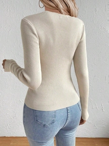 Detail of beige ribbed knit sweater showing slim fit texture and vertical stripe pattern