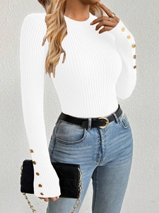 Close-up of white ribbed knit sweater featuring elegant gold buttons on sleeve cuffs