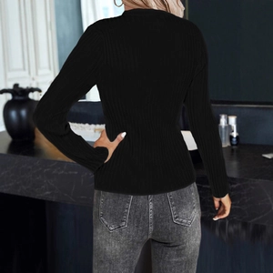 Rear view of women's black ribbed knit top paired with faded grey denim jeans