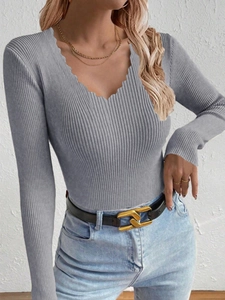 Detail of grey ribbed knit sweater featuring a stylish scalloped V-neckline for women