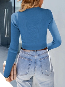 Rear view of a blue ribbed knit long sleeve crop top with irregular cut-out details