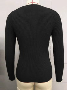 Close-up of black ribbed knit sweater showing fitted long sleeve design on mannequin