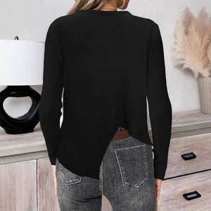 Détail d'un pull en maille noire avec ourlet fendu croisé et texture côtelée dans le dos