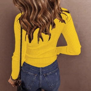 Detail view of yellow ribbed knit sweater with lace splicing on back and blue jeans