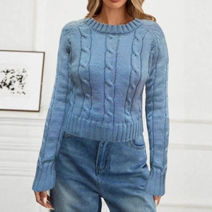 Detailed close-up of light blue knit sweater featuring classic cable knit texture patterns