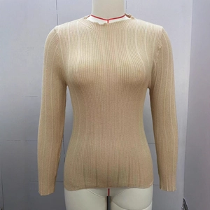 Detail of apricot ribbed knit sweater showing soft texture and slim fit round neck design