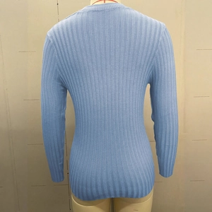 Close-up of light blue knit sweater showing vertical ribbing texture and slim fit design