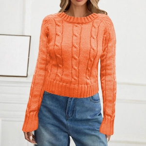 Close-up of orange cable knit sweater featuring round neck and thick ribbed texture