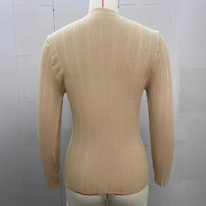 Detail view of the ribbed knit texture and slim fit back design of a beige sweater