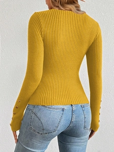 Detail view of the long sleeve knit top featuring gold decorative buttons on cuffs