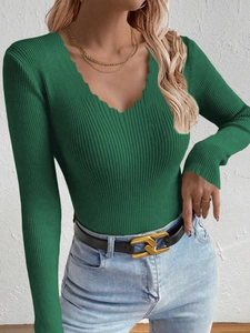 Detail of slim fit dark green ribbed knit sweater featuring a wavy scalloped V-neckline