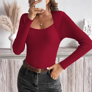 Dettaglio del top in maglia a coste rosse con profondo scollo a U e texture a righe