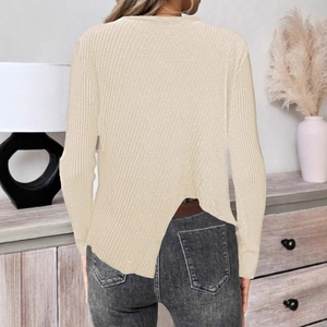 Détail d'un pull en maille côtelée beige avec une fente asymétrique unique au bas du dos