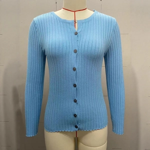 Close-up of light blue knit cardigan featuring vertical ribbed texture and black buttons