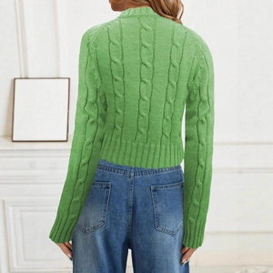 Detail of light green cable knit sweater texture and ribbed cuff on female model