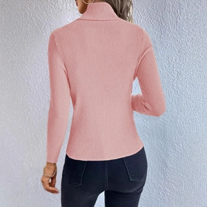 Detail view of pink turtleneck sweater featuring vertical ribbed texture and slim fit design