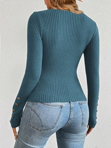 Detail view of teal ribbed knit sweater sleeves featuring decorative gold buttons on cuffs