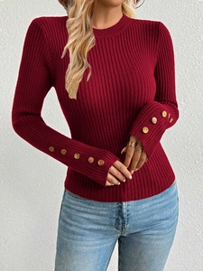 Close-up of golden buttons on wine red ribbed knit sweater cuffs with slim fit design