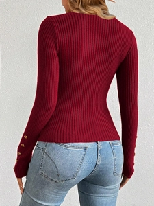 Detail view of burgundy ribbed knit sweater featuring elegant gold buttons on cuffs