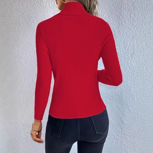 Close-up of red ribbed knit texture and back tailoring on a high-neck sweater